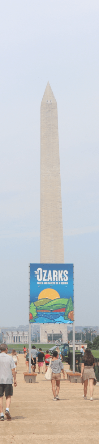 The Washington Monument stands behind a sign for "The Ozarks: Faces and Facets of a Region"